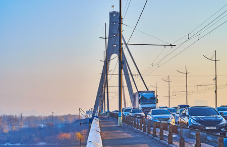 The busy morning traffic on Pivnichnyi (Northern) Bridge with a view of hazy sunrise sky and Dnieper River, Kyiv, Ukraineのeditorial素材