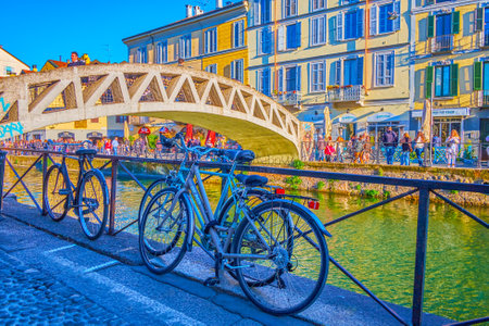 MILAN, ITALY - APRIL 9, 2022: The bicycles parked at the handrails of Naviglio Grande Canal, on April 9 in Milan, Italyのeditorial素材