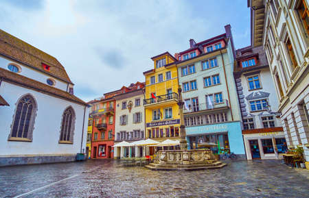 LUCERNE, SWITZERLAND - MARCH 30, 2022: Franziskaner platz square with historica fountain and colorful houses, on March 30 in Lucerne, Switzerlandの写真素材
