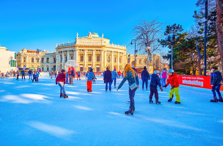 VIENNA, AUSTRIA - FEBRUARY 17, 2019: People enjoy winter skating on large ice rink on Rathausplatz, on February 17 in Vienna, Austriaのeditorial素材