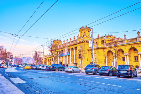 BUDAPEST, HUNGARY - MARCH 2, 2022: Szechenyi Thermal Spa and car parking along the road, on March 2...