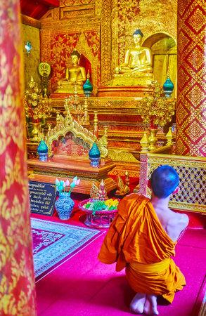 CHIANG MAI, THAILAND - MAY 3, 2019: The bhikkhu monk prays in Viharn Lai Kham of Wat Phra Singh, on May 3 in Chiang Maiのeditorial素材