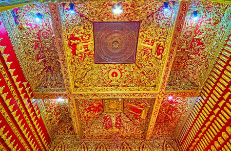 CHIANG MAI, THAILAND - MAY 3, 2019: The red wooden ceiling of the shrine-library of Wat Buppharam, decorated with fine gilt relief ornaments, Chiang Maiのeditorial素材