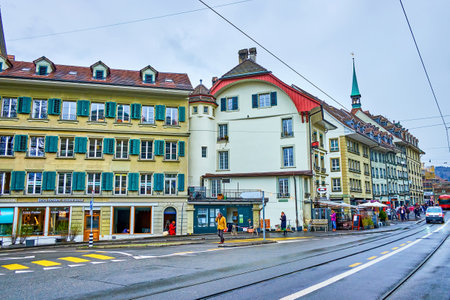 BERN, SWITZERLAND - MARCH 31, 2022: Urban scene on Kornhausplatz square with historic townhouses with green window shutters, on March 31 in Bern, Switzerlandのeditorial素材