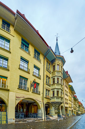 BERN, SWITZERLAND - MARCH 31, 2022: Panoramic view on the line of residential houses on Munstergasse street with ornate decorations, on March 31 in Bern, Switzerlandのeditorial素材