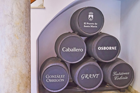 EL PUERTO, SPAIN - SEPT 21, 2019: The vintage black wooden casks of Caballero, Osborne, Gonzalez...