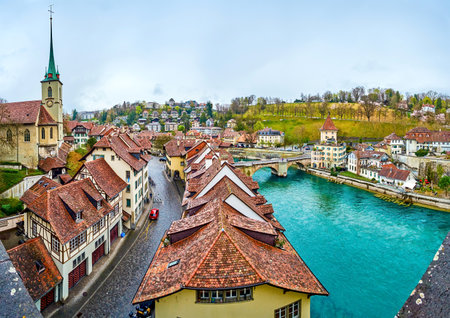 The cityscape of the oldest part of Bern with outstanding townhouses, Nydegg church and Untertorbrucke bridge across Aare river, Switzerlandのeditorial素材