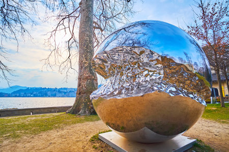 LUGANO, SWITZERLAND - MARCH 13, 2022: The sphere shaped Big Data sculpture by Helidon Xhixha in Parco Ciani on Ceresio bank, on March 13 in Luganoのeditorial素材