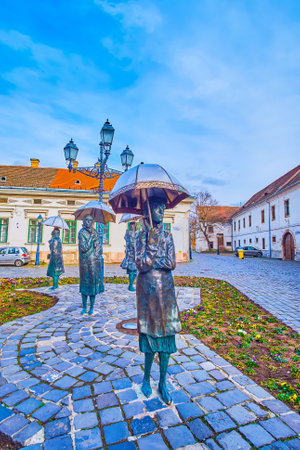 BUDAPEST, HUNGARY - FEBRUARY 26, 2022: Szindbad Square of Obuda with Ladies with Umbrellas statues by Imre Varga, on February 26 in Budapestのeditorial素材