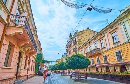 The scenic cityscape of Chernivtsi, lush green trees and historic houses on Kobylyanska street in city centre, Ukraineのeditorial素材