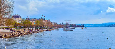ZURICH, SWITZERLAND - APRIL 3, 2022: Panorama of Lake Zurich and its embankment with recreation area...