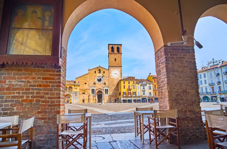 The Piazza della Vittoria with Duomo di Lodi (Cathedral) and historic houses through the brick arch, Lodi, Lombardy, Italyの写真素材