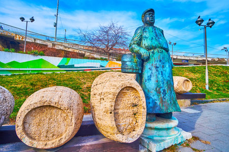 BUDAPEST, HUNGARY - MARCH 3, 2022: The sculptural composition of Wine Merchant with barrels, located on Boraros Square, Ferencvaros, Budapest, Hungaryのeditorial素材