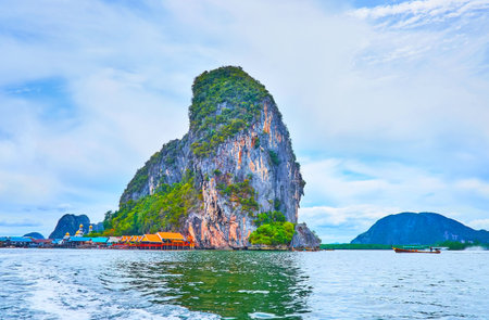 The scenic landscape of Ko Panyi Island and colored roofs of floating village, located at the rock's foot, Phang Nga Bay, Thailandの写真素材