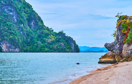 The rocky Ko Raya Ring Island, covered with tropic vegetation is seen from the sand coast of James Bond Island, Phang Nga Bay, Thailandの写真素材