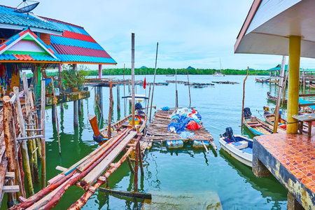 The rickety fishing pier, made of old sticks and rotten boards in Ko Panyi floating village, Phang Nga Bay, Thailandの写真素材