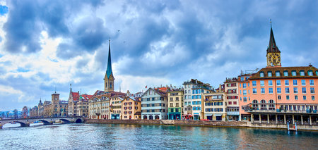 Panorama of the riverside housing of Limmat river with bell towers of Peterskirche and Fraumunster churches, Zurich, Switzerlandの写真素材