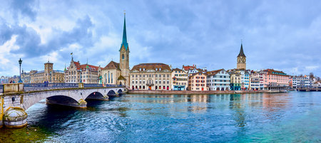 Panorama of the riverside housing of Limmat river with bell towers of Peterskirche and Fraumunster churches, Zurich, Switzerlandの写真素材