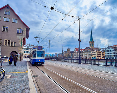 Vintage tram rides along the Limmatquai embankment, passing by historic residential houses in Zurich, Switzerlandの写真素材