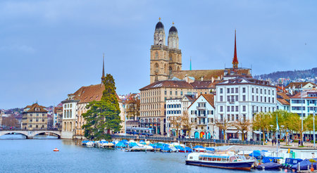 The iconic bell towers of Grossmunster church rise above the rooftops, defining the skyline of Zurich, Switzerland.の写真素材