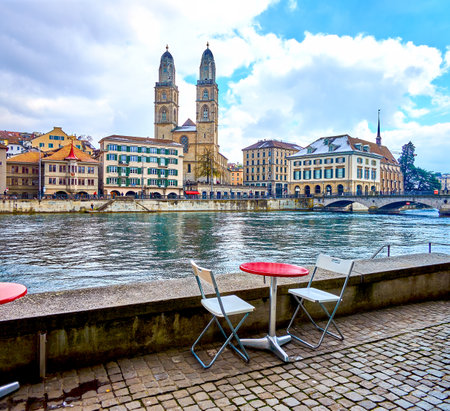 Restaurant's outdoor seating on the Wuhre promenade with view on Grossmunster church, Zurich, Switzerlandの写真素材