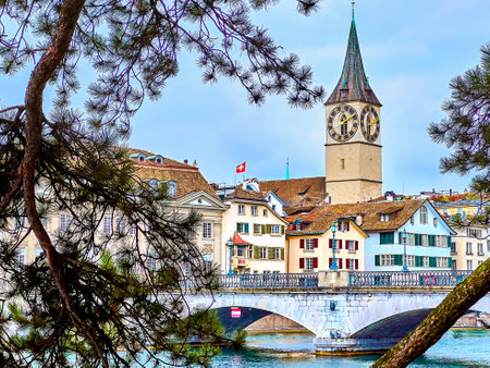 The stunning Peterskirche church framed by the pine tree branches offers a captivating view in Zurich, Switzerland.の写真素材
