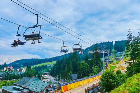BUKOVEL, UKRAINE - JULY 24, 2021: The skilift, riding to the Mount Bukovel, covered with conifer forests and tourist routes, on July 24 in Bukovelの写真素材