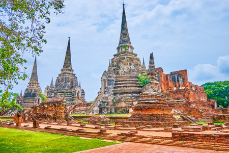 The ancient brick chedis, green lawn and shady trees in Wat Phra Si Sanphet archaeological Buddhist site, Ayutthaya, Thailandの写真素材