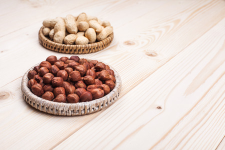 peanuts and hazelnuts in diet , weight loss and healthy nutrition concept  lying on wooden table with place for textの写真素材