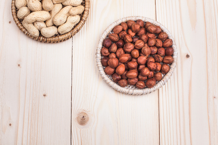 peanuts and hazelnuts in diet , weight loss and healthy nutrition concept  lying on wooden table with place for textの写真素材