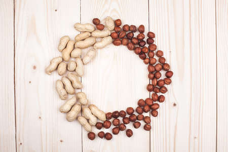 round frame peanuts and hazelnuts in diet, weight loss and healthy nutrition concept  lying   On wooden tableの写真素材