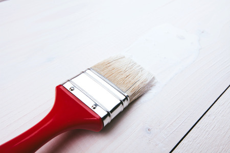 Varnishing and painting a wooden shelf using paintbrushの写真素材