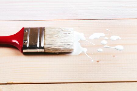 Brush painting wooden furniture with white color, close upの写真素材