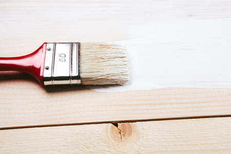 Varnishing and painting a wooden shelf using paintbrushの写真素材