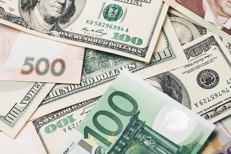 Money: dollars, the hryvnia , the euro , and Swiss francs lying on white wooden table in a rowの写真素材