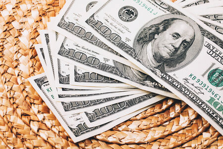 Money fan of dollars lying on Wicker surfaceの写真素材