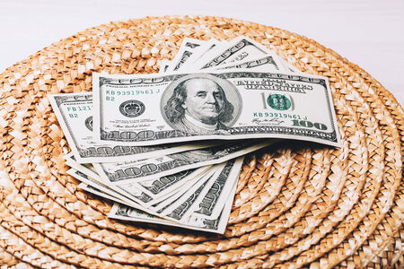 Money fan of dollars lying on Wicker surfaceの写真素材