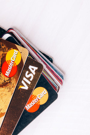 stack of different visa, mastercard cards lying on white backgroundのeditorial素材