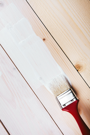Varnishing and painting a wooden shelf using paintbrushの写真素材