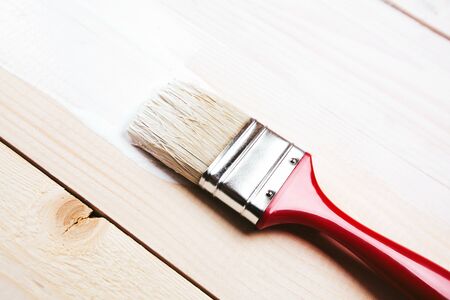 Varnishing and painting a wooden shelf using paintbrushの写真素材
