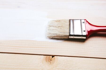 painting a wooden shelf using paintbrush with white colorの写真素材