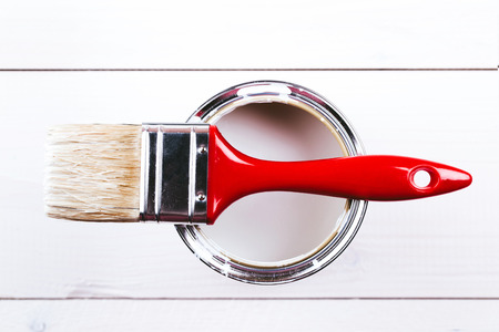 Varnishing and painting a wooden shelf using paintbrush with white colorの写真素材