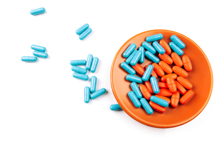 Colored pills on the plate isolated on whiteの写真素材