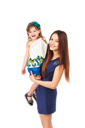 Beautiful young smiling sexy woman holding her smiling little daughter, isolated on white backgroundの写真素材
