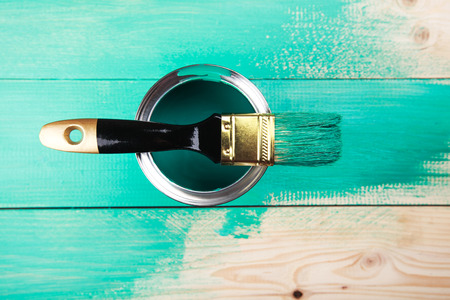 Varnishing a wooden shelf using paintbrush, turquoise colorの写真素材