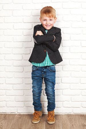 Portrait of happy joyful beautiful little boy in a jacketの写真素材