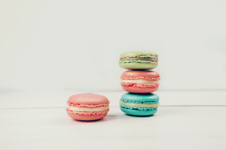Colorful macarons lying on wooden white backgroundの写真素材