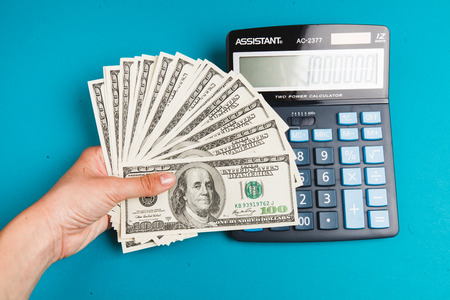 savings, finances, economy and concept - close up of man with calculator counting moneyの写真素材