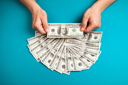 Mans hands holding dollars on dollars background, closeupの写真素材