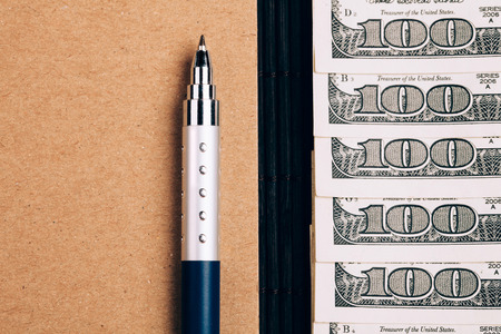 note book, pen and dollars, planning and saving  money concept, closeupの写真素材